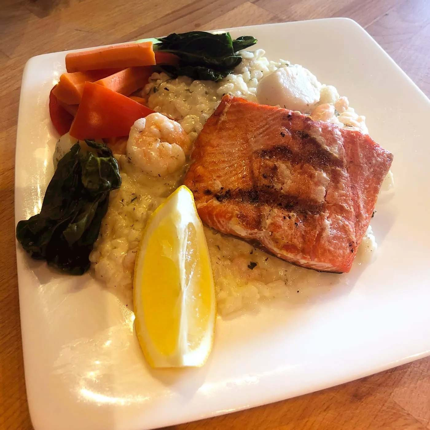Salmon served on a seafood risotto