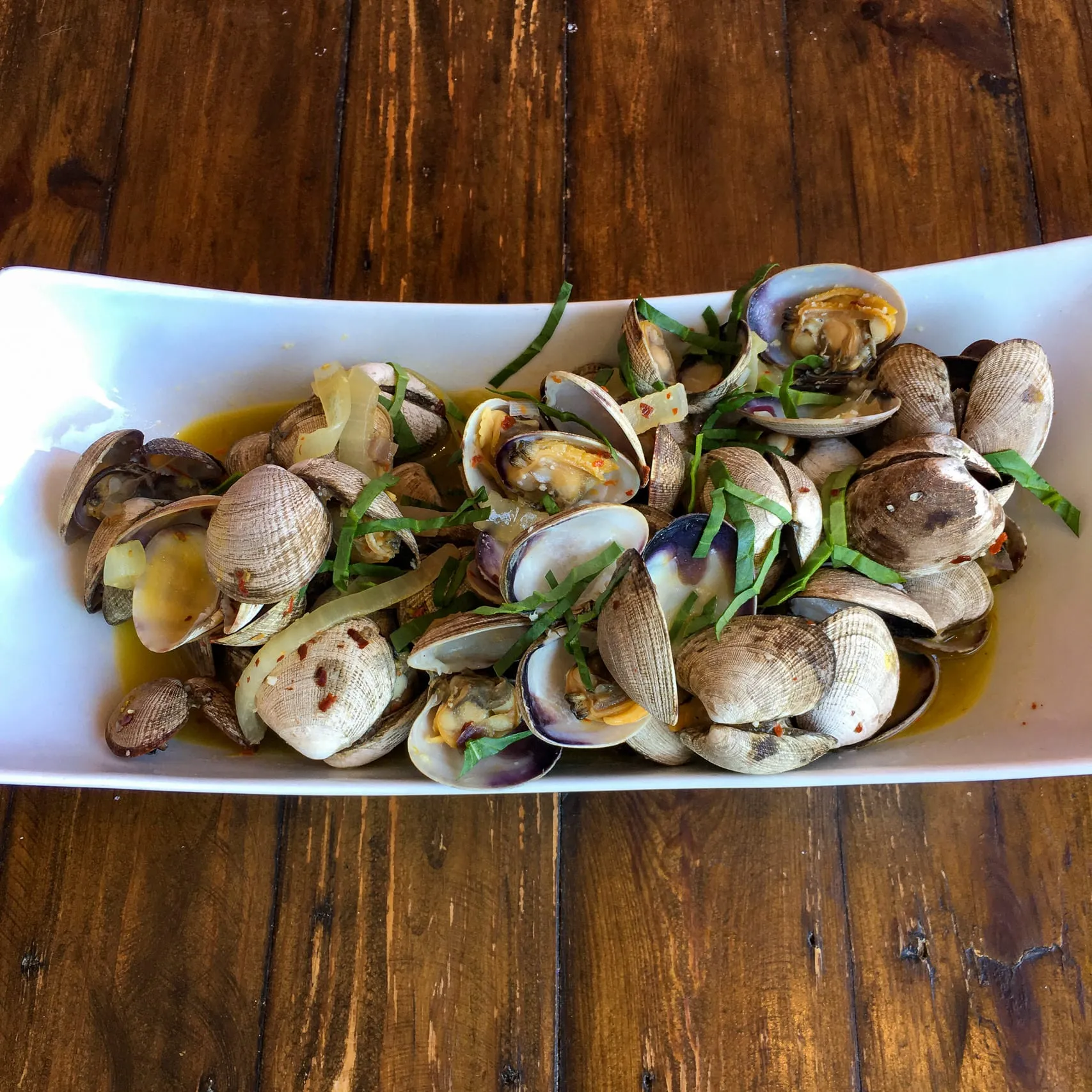 A platter of steamed clams with basil and chilli